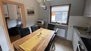 Et kompakt køkken med spiseplads, en mikrobølgeovn, en vask og et vindue med udsigt.