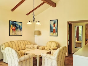 Une pièce comprenant un canapé, une table, une lampe et deux tableaux.