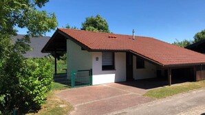 A single-story house with a red-tiled roof, a covered porch, and a fenced yard. - K5 Haus in Eckwarderhörne mit Terrasse und Garte by Interhome (Burhave)