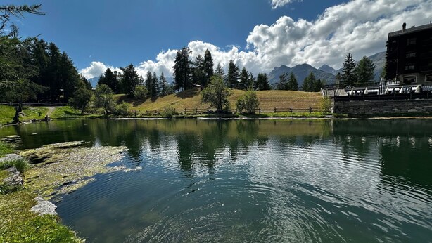 A calm lake with a stone bridge, surrounded by trees and mountains. - Sunnuhof Lodge by Interhome (Grächen)