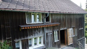 A rustic wooden building with a sloped roof, multiple windows, and a picnic table outside. - Ruchweid by Interhome (Ebnat-Kappel)