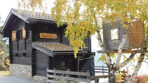 Een rustieke hut met een stenen fundering, houten gevel en een bord met de tekst 'Schloss Felsen'.