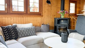 Una sala de estar acogedora con un sofá, una mesa redonda y una estufa de leña.