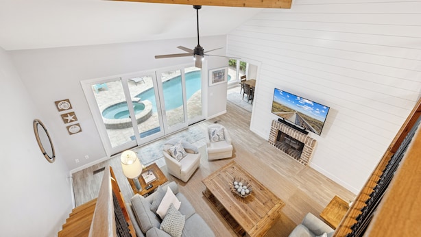 A spacious living area with a pool view, a fireplace, and a television. - 7 Strath Court @ Palmetto Dunes | Private Pool | Pet Friendly | Cozy Loft | Spacious Kitchen (Hilton Head Island)