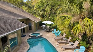 A backyard with a swimming pool, lounge chairs, and a barbecue area. - 7 Strath Court @ Palmetto Dunes | Private Pool | Pet Friendly | Cozy Loft | Spacious Kitchen (Hilton Head Island)