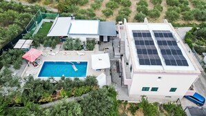 An aerial view of a residential property with a swimming pool, solar panels, and a garden. - Villa Rimac in Kastel Stafilic mit Garten, Grill by Interhome (Kaštel Novi)