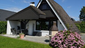 Ein Haus mit geneigtem Dach, Schornstein und Satellitenschüssel.