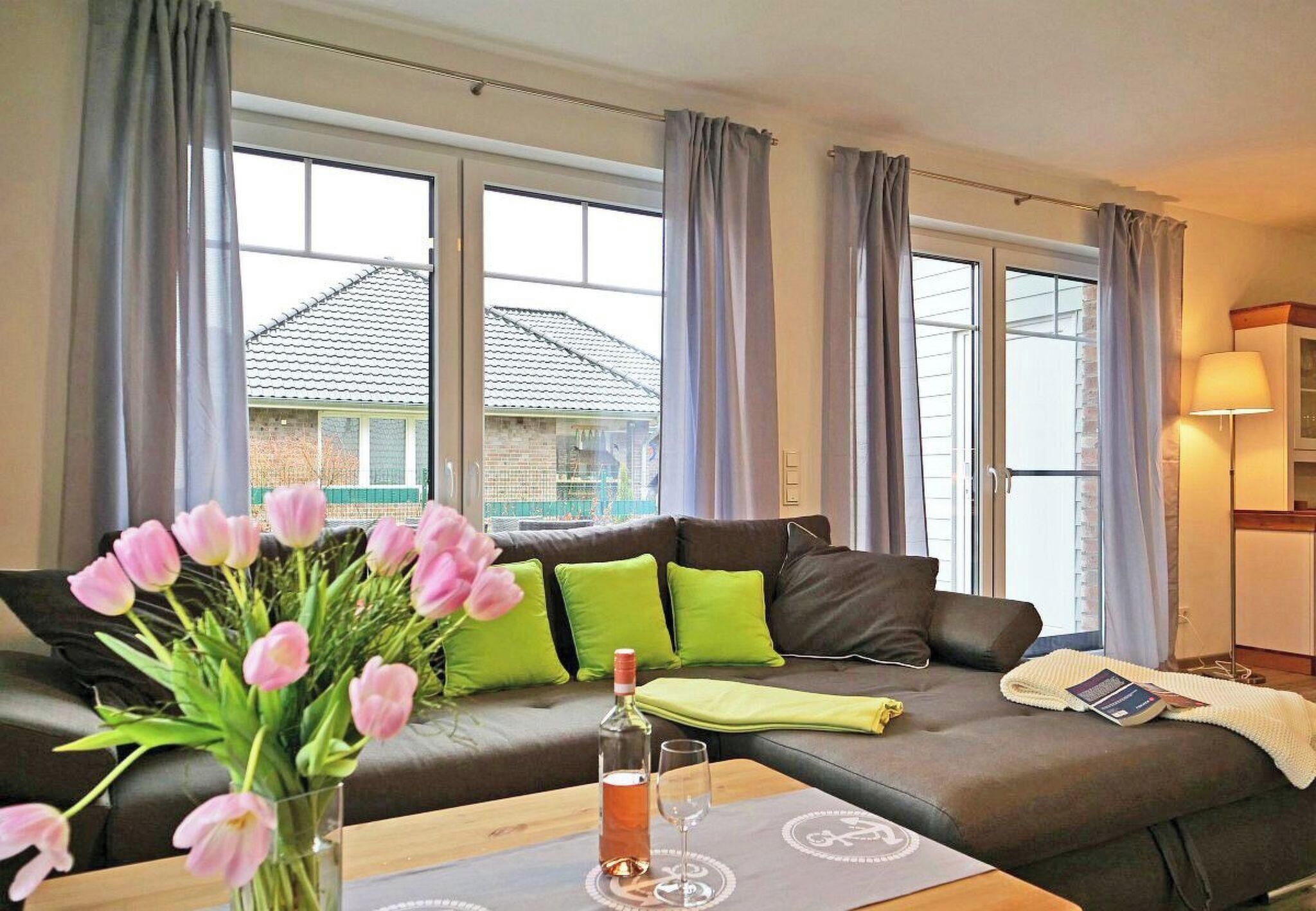 A modern living room with a sofa, a table with a vase of flowers, and a lamp.
