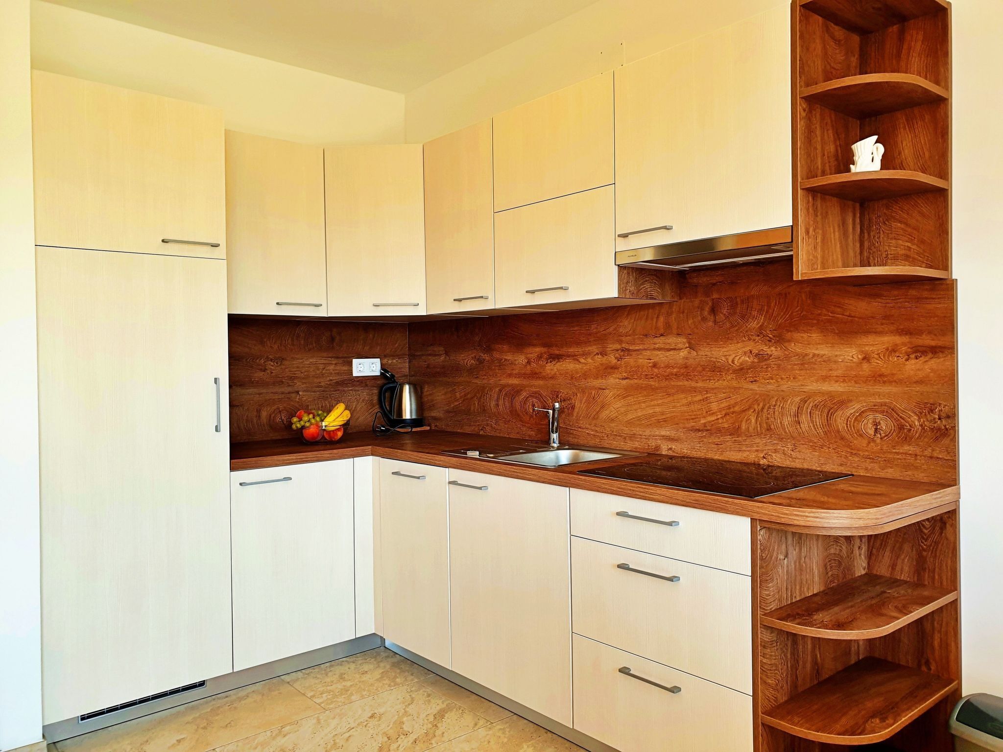 Eine moderne Küche mit hellen Schränken, einer Holzrückwand und einer eingebauten Holzregaleinheit.