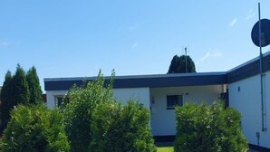 A building with a flat roof, a satellite dish, and a paved entrance. - in Tossens mit Schönem Garten by Interhome (Burhave)