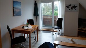 A cozy room with a wooden table, two chairs, a glass of wine, a bottle, and a world map on the wall. - Kajüte in Fedderwardersiel by Interhome (Burhave)