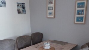 En matplats med ett träbord och sex grå stoppade stolar.