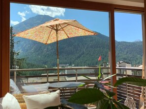 A balcony with a view of a mountain, an umbrella, and a plant. - MFH Terr‘in tschêl by Interhome (Pontresina)