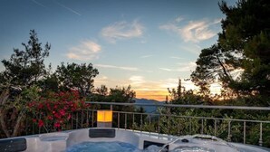 A hot tub with a view of a sunset and mountains. - Privatwohnung mit Jacuzzi und Schwimmbad by Interhome (Split/Žrnovnica)