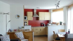 En modern lägenhet med vardagsrum, matplats och kök.
