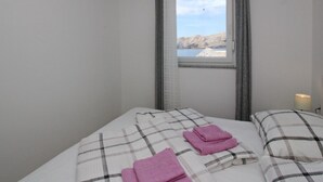 Ein Hotelzimmer mit einem Bett, einem Fenster mit Bergblick und einer Lampe.
