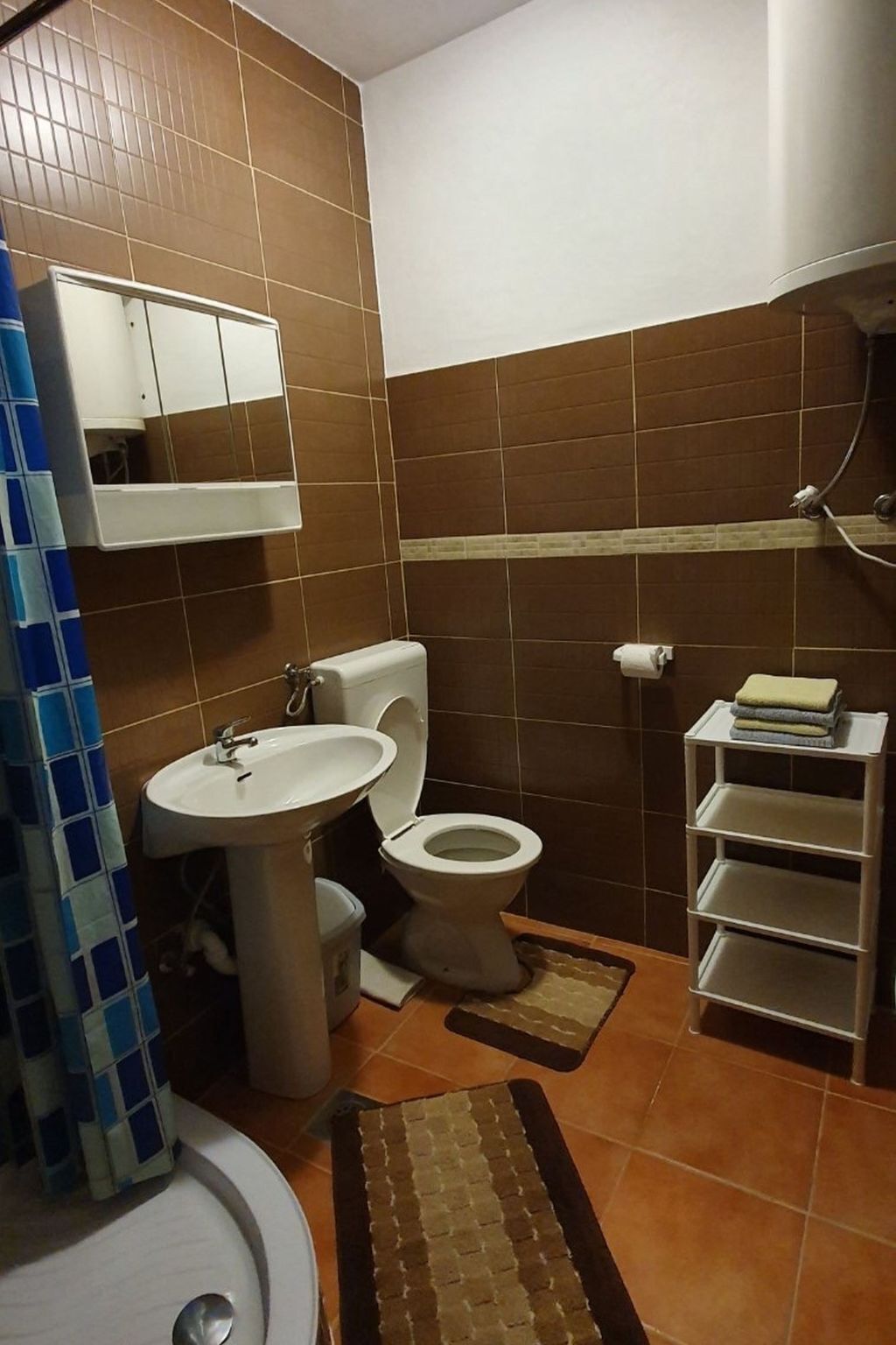 Ein Badezimmer mit Toilette, Waschbecken und einer kleinen Ablagefläche.