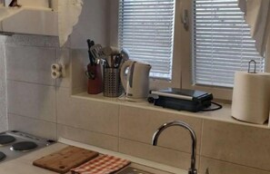Geladeira, fogão, talheres/pratos/utensílios de cozinha