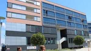 Ein modernes, mehrgeschossiges Gebäude mit einer Fassade aus Glas und Metall, einem sichtbaren Schild für 'Solaris' und einer Treppe, die zu einem Eingang führt.