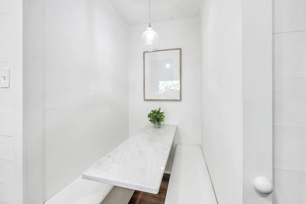 A bathroom with a white marble sink, a hanging pendant light, and a framed mirror on the wall. - Coastal Cove*Splash Pool*Walk to Beach*Free Beach Setup (Miramar Beach)