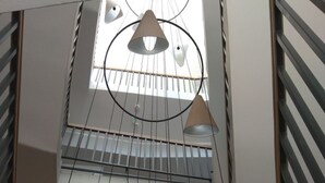 Un intérieur à plusieurs niveaux, doté d’une verrière, de rampes en métal et de lampes suspendues.