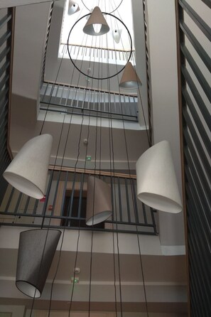 A multi-level interior with a skylight, metal railings, and hanging lamps. - Apartament Cesarski Agnes by Interhome (Swinoujscie)