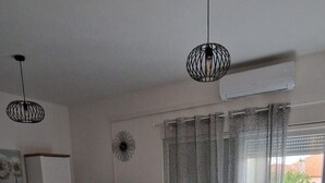 Una sala de estar moderna con una mesa de comedor, sillas, televisor y sofá.