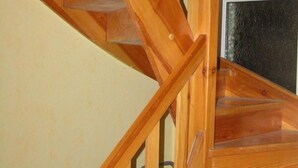 Eine Holztreppe mit Geländer und einem Holzgeländerende.