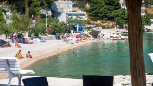 A beach with clear water, lounge chairs, and umbrellas. - Wohnung "Apartman für 4 Personen" by Interhome (Brela)