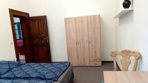 A bedroom with a bed, a wardrobe, a chair, and a small table. - Appartement mit eigenem Parkplatz by Interhome (Jüterbog)