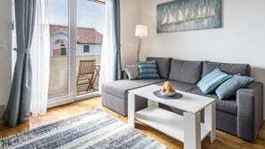 A modern living room with a grey sofa, a white coffee table, and a painting of sailboats. - "Villa Tango1" mit eigenem Pool by Interhome (Trogir/Okrug Donji)