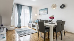 A modern living room with a dining area, featuring a sofa, a coffee table, and a dining table with chairs. - "Villa Tango1" mit eigenem Pool by Interhome (Trogir/Okrug Donji)