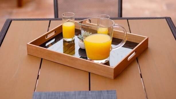 A tray with three glasses of orange juice on a wooden table by a poolside. - "Villa Tango1" mit eigenem Pool by Interhome (Trogir/Okrug Donji)