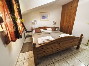 A bedroom with a wooden bed, a nightstand, a wardrobe, and a painting on the wall. - Wohnung "Antica 05" direkt am Strand by Interhome (Nin)