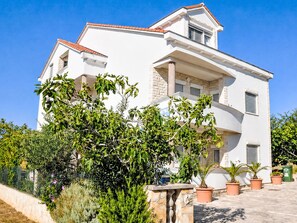 A two-story building with a white facade, a red-tiled roof, and a balcony. - Wohnung "Antica 05" direkt am Strand by Interhome (Nin)