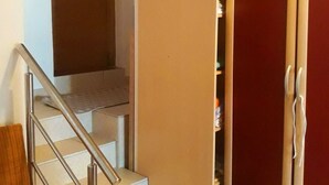 Eine Treppe führt zu einem Raum mit einem Schrank und einem kleinen Tisch.