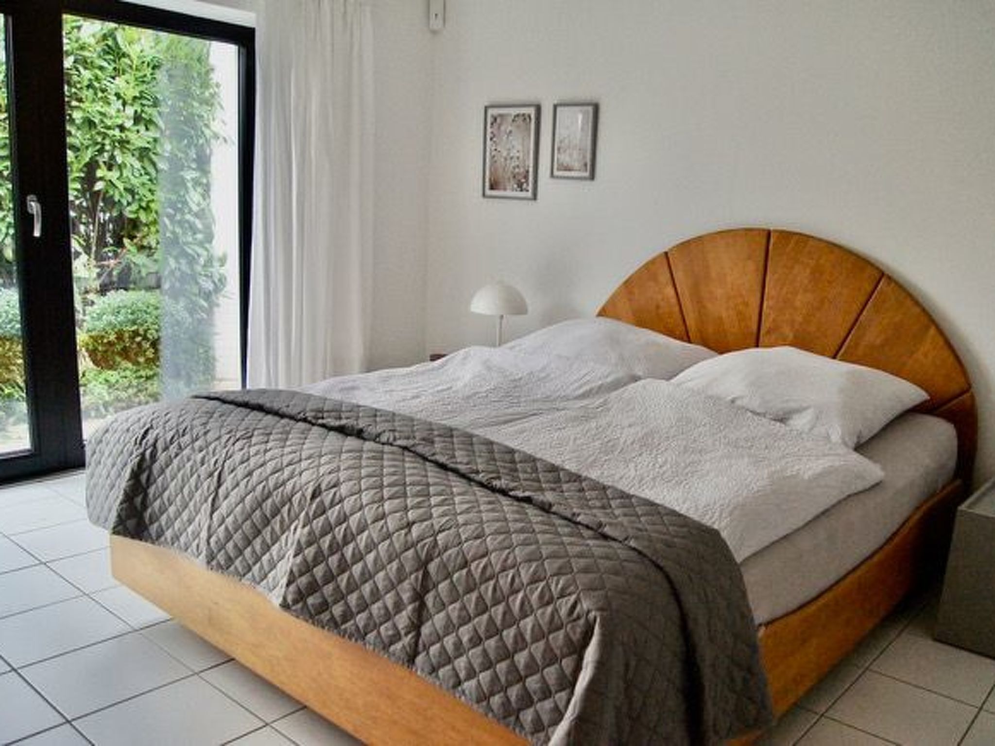 A bedroom with a bed, a window, and a door.
