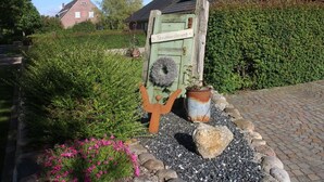 Un cartello di legno rustico con una casa e del verde sullo sfondo.
