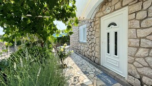 Un edificio in pietra con una porta bianca e un tappetino d'ingresso.