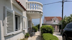 Una casa con un vialetto in pietra che conduce a un portico coperto con mobili da esterno.