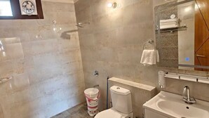 Ein Badezimmer mit Dusche, Toilette, Waschbecken und Handtuchhalter.