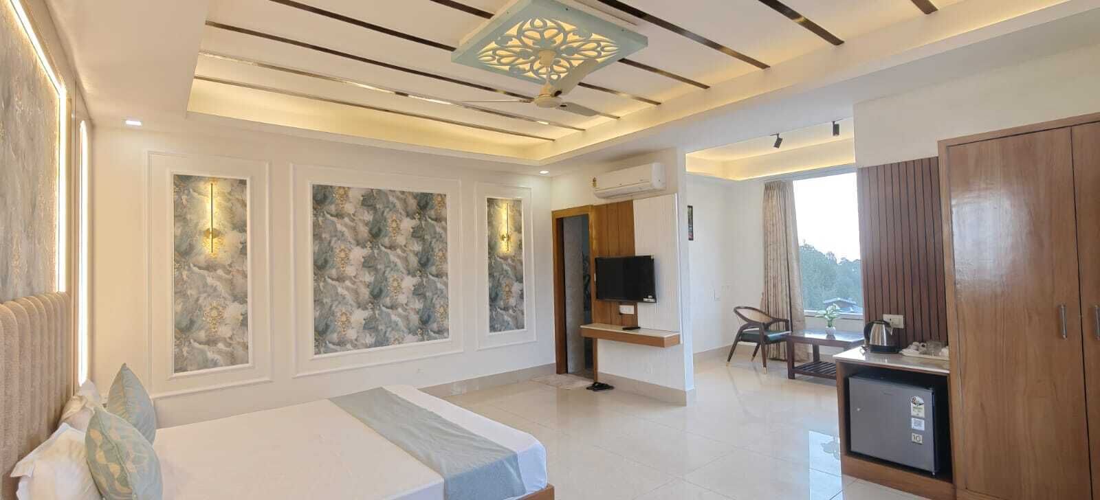 A hotel room with a bed, a desk, a television, and a wardrobe.
