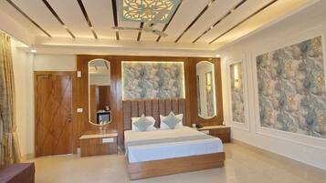 A modern bedroom with a large bed, a vanity with a mirror, and a decorative wall panel.
