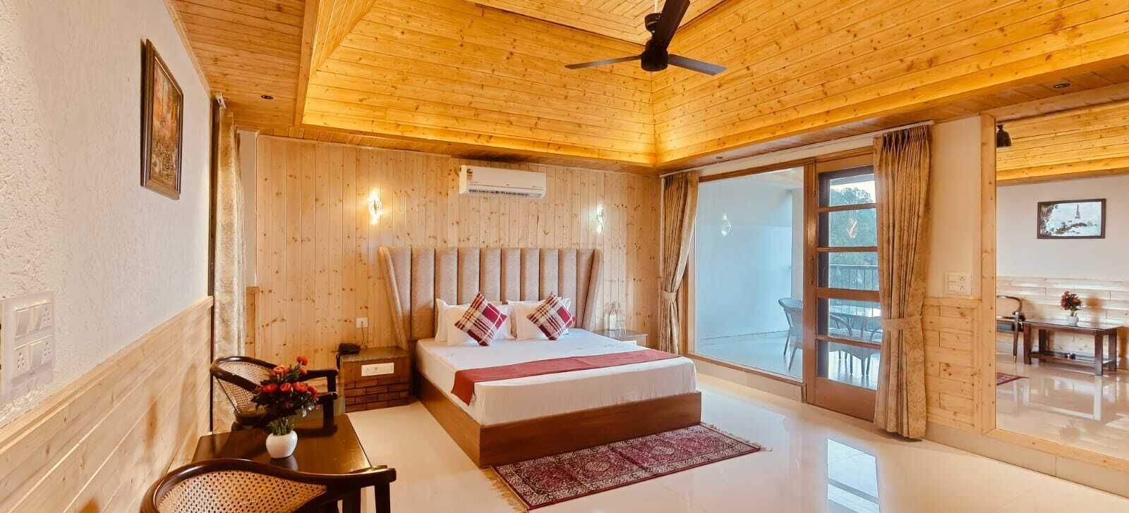 Een slaapkamer met houten lambrisering, een bed, een bureau en een stoel.