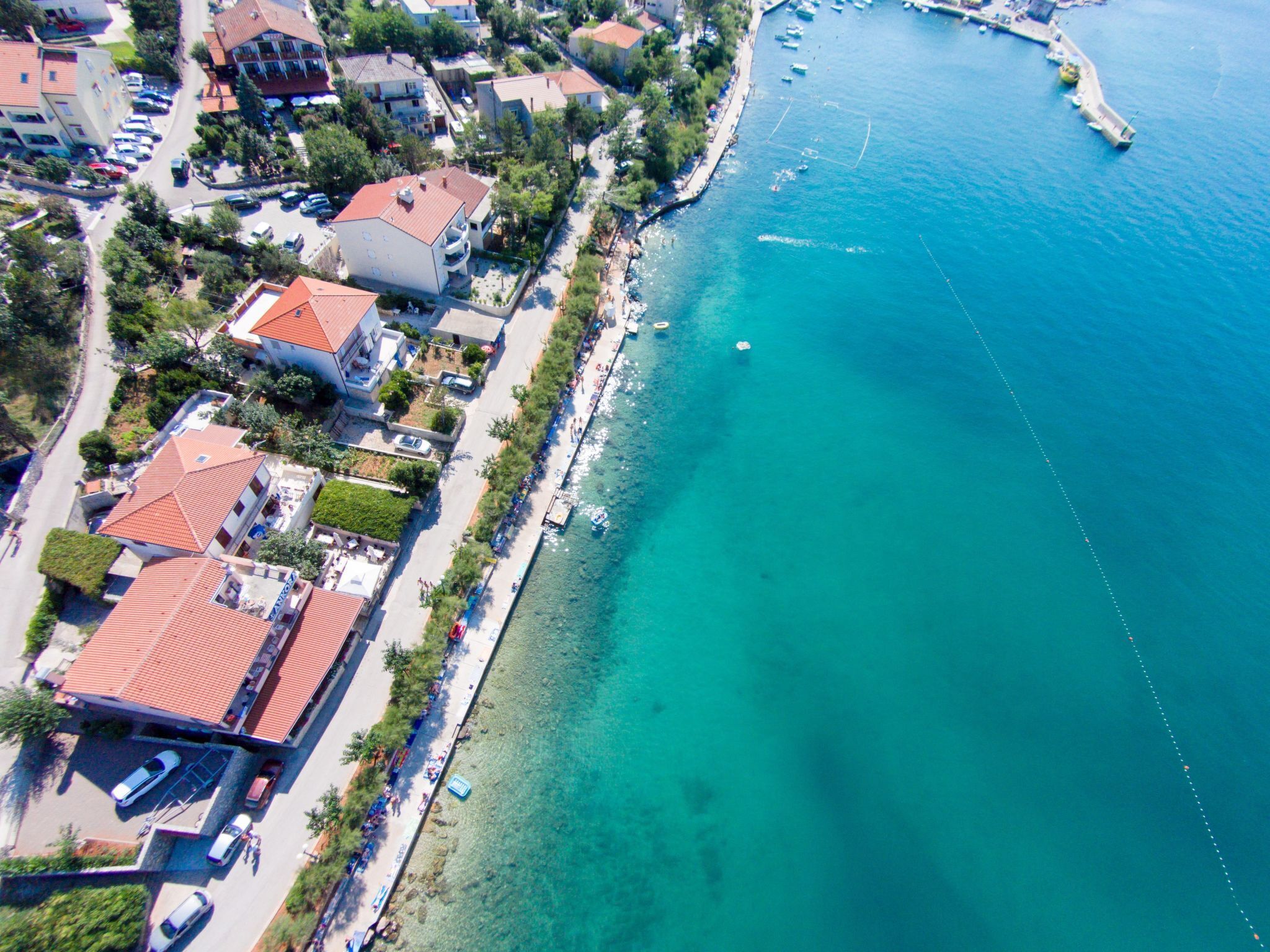 Une vue aérienne d’une ville côtière, avec ses bâtiments, sa plage et ses bateaux.