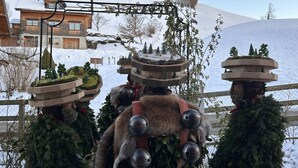 A rustic wooden building with a snow-covered roof, surrounded by a snowy landscape and a wooden fence. - Sonnige Maisonette by Interhome (Dicken)