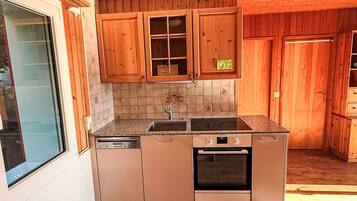 A kitchen with wooden cabinets, a dishwasher, an oven, and a window.