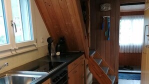 Une cuisine avec des meubles de rangement en bois, une cuisinière et un évier.