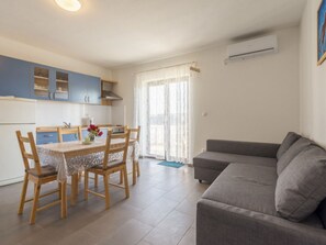 Um espaço compacto com cozinha compacta, área de refeições e sofá.