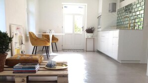 Moderni keittiö, jossa on valkoiset kaapit, laatoitettu välitila ja ikkuna, josta tulee luonnonvaloa.